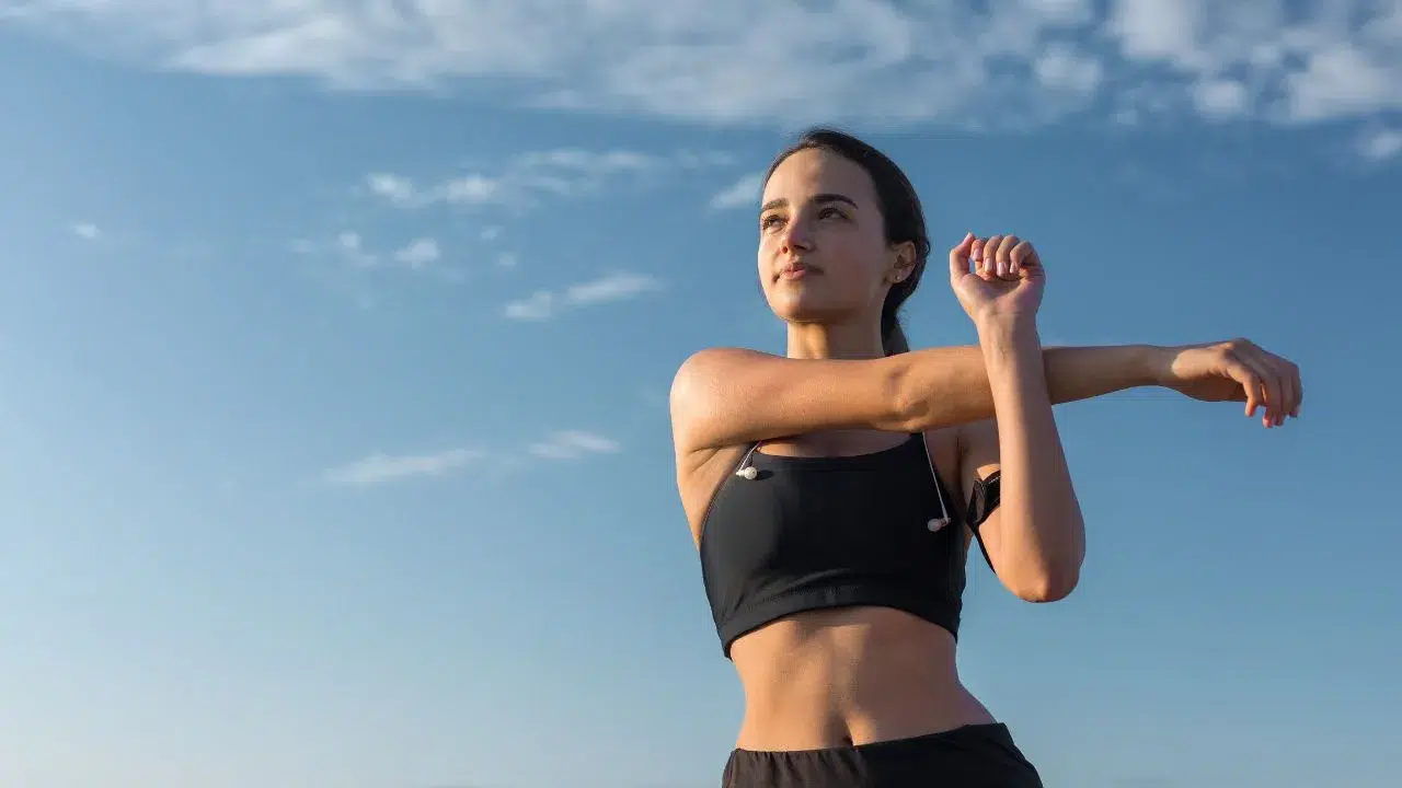 Slim athletic girl performs stretching exercises